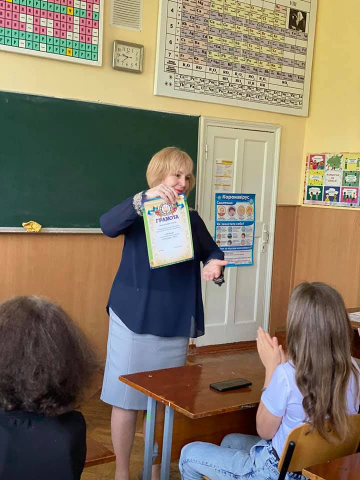 Оксана Якубова нагороджує найкращих учнів школи в кінці навчального року, травень 2021 року. Фото: facebook.com/groups/2NKBahuty/