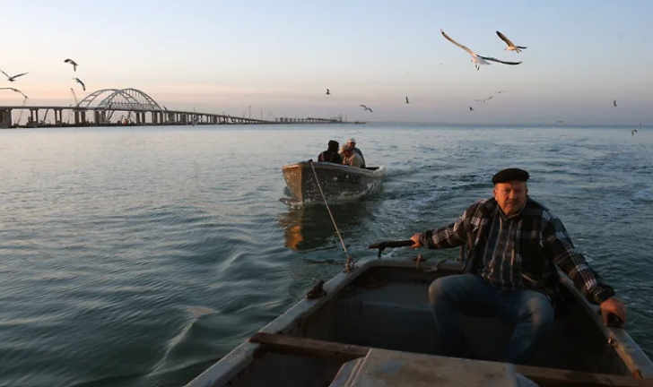 Рибалки на фоні Керченського мосту. Фото: Коммерсантъ