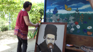 Інна Сезоненко поруч із врятованим нею портретом Тараса Шевченка