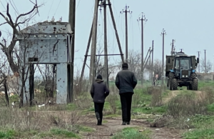 Місцеві люди йдуть біля розбитої трансформаторної будки. Фото: Олег Батурін/ЦЖР