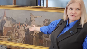 Колаборантка Наталія Десятова демонструє викрадені за її участю картини на Херсонщині, грудень 2025 року. Скріншот відео окупаційних пабліків